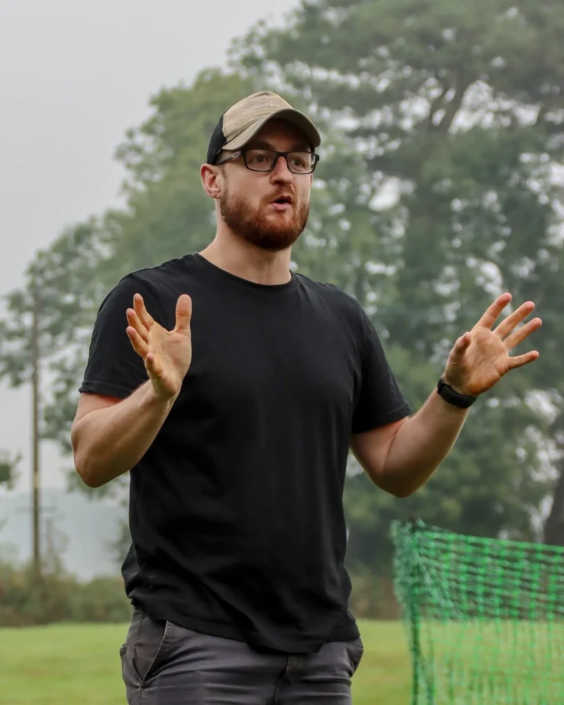 Ben coaching outdoors, mid-explanation, in a black Truffle Forager t-shirt