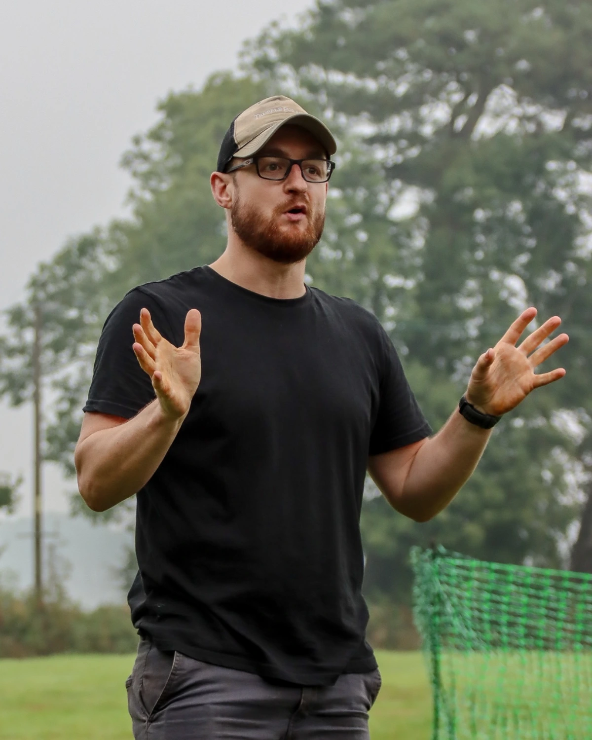 Ben coaching outdoors, mid-explanation, in a black Truffle Forager t-shirt